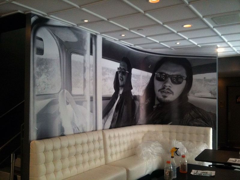 Modern lounge with tufted white banquette and a large black-and-white wall mural of a man