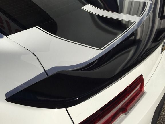 Rear view of a white sports car with black spoiler and red taillight accent
