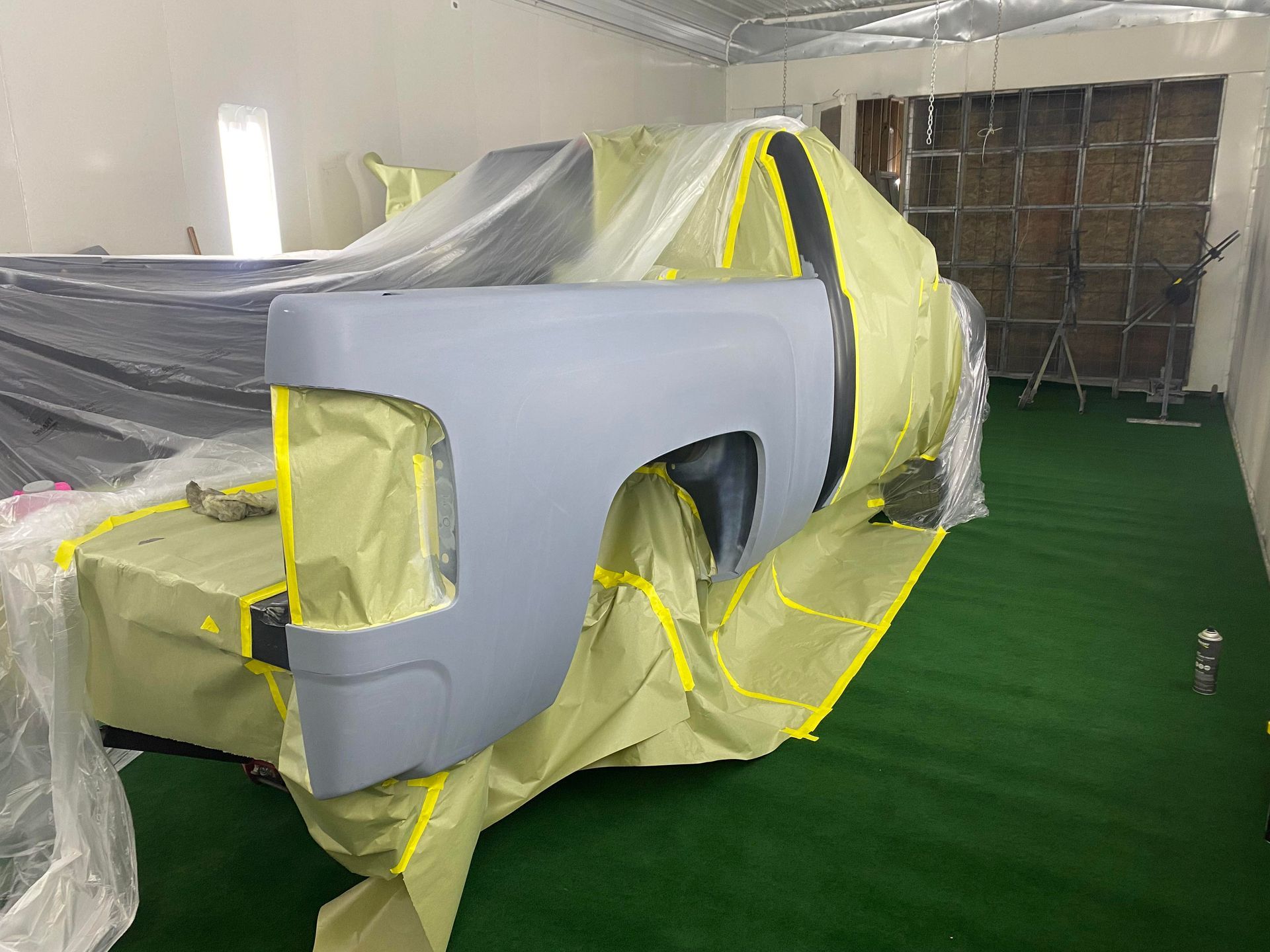 a truck is being painted in a paint booth