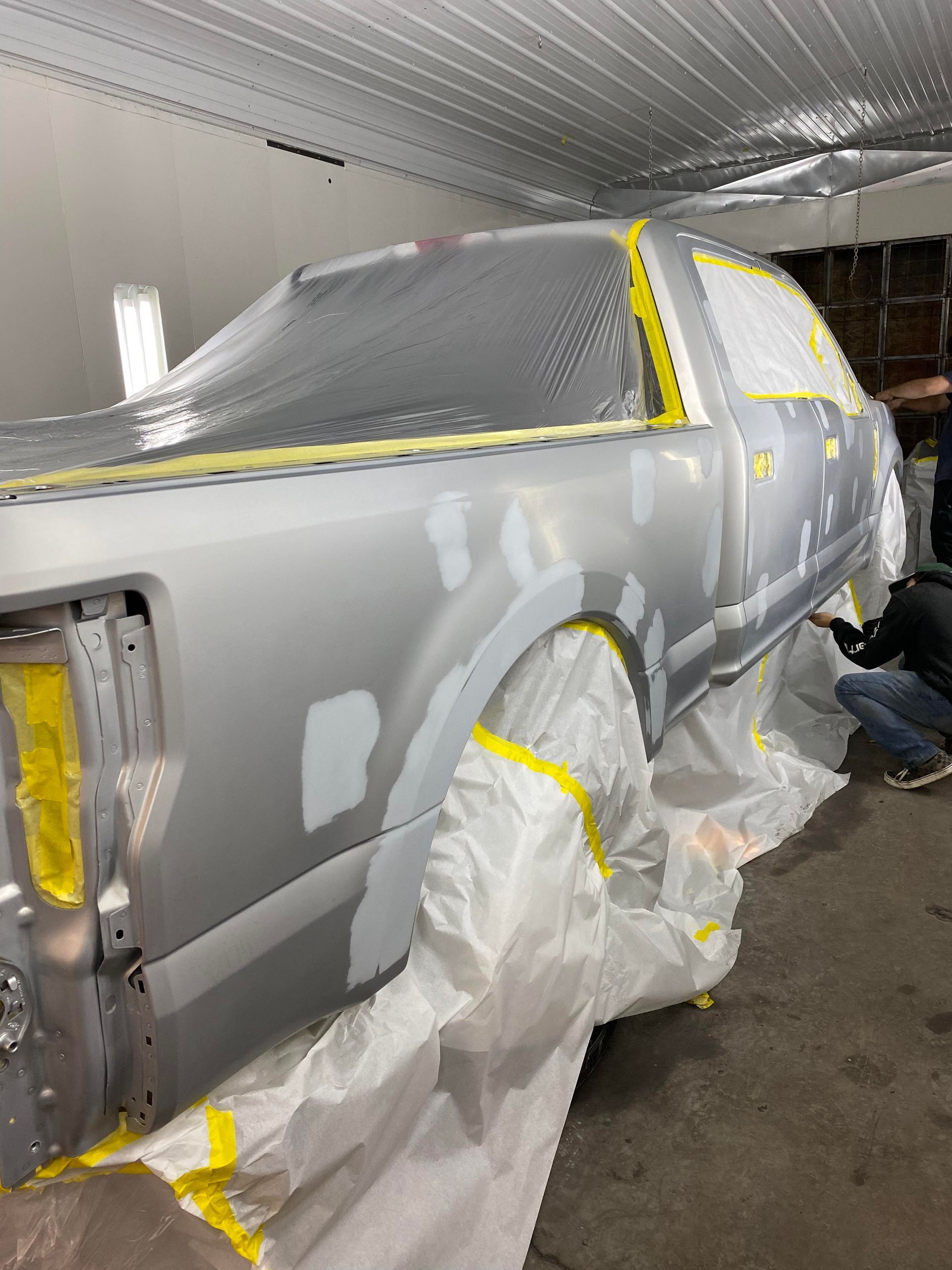 a silver truck is being painted in a garage