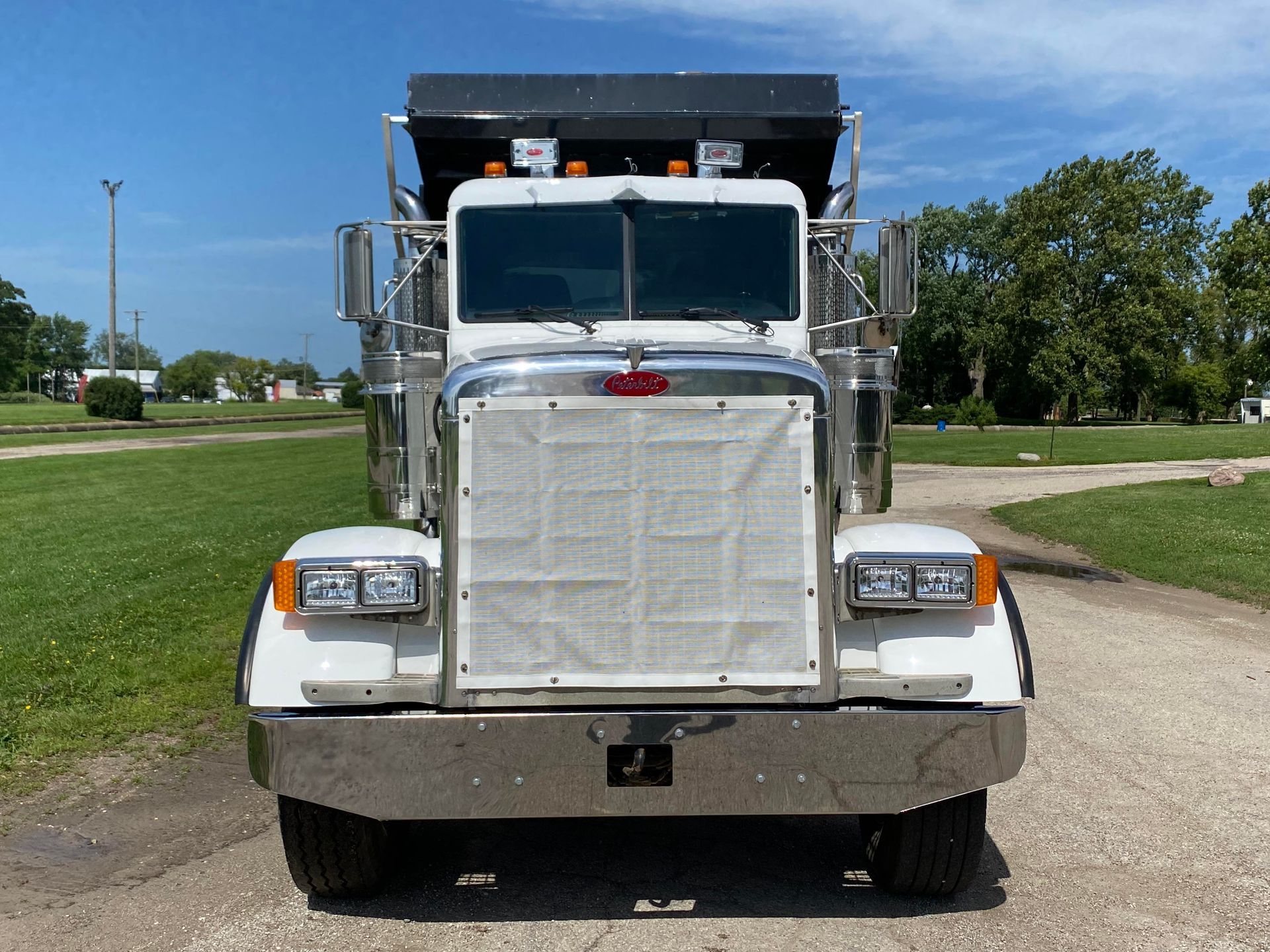 a white dump truck is parked on a dirt road