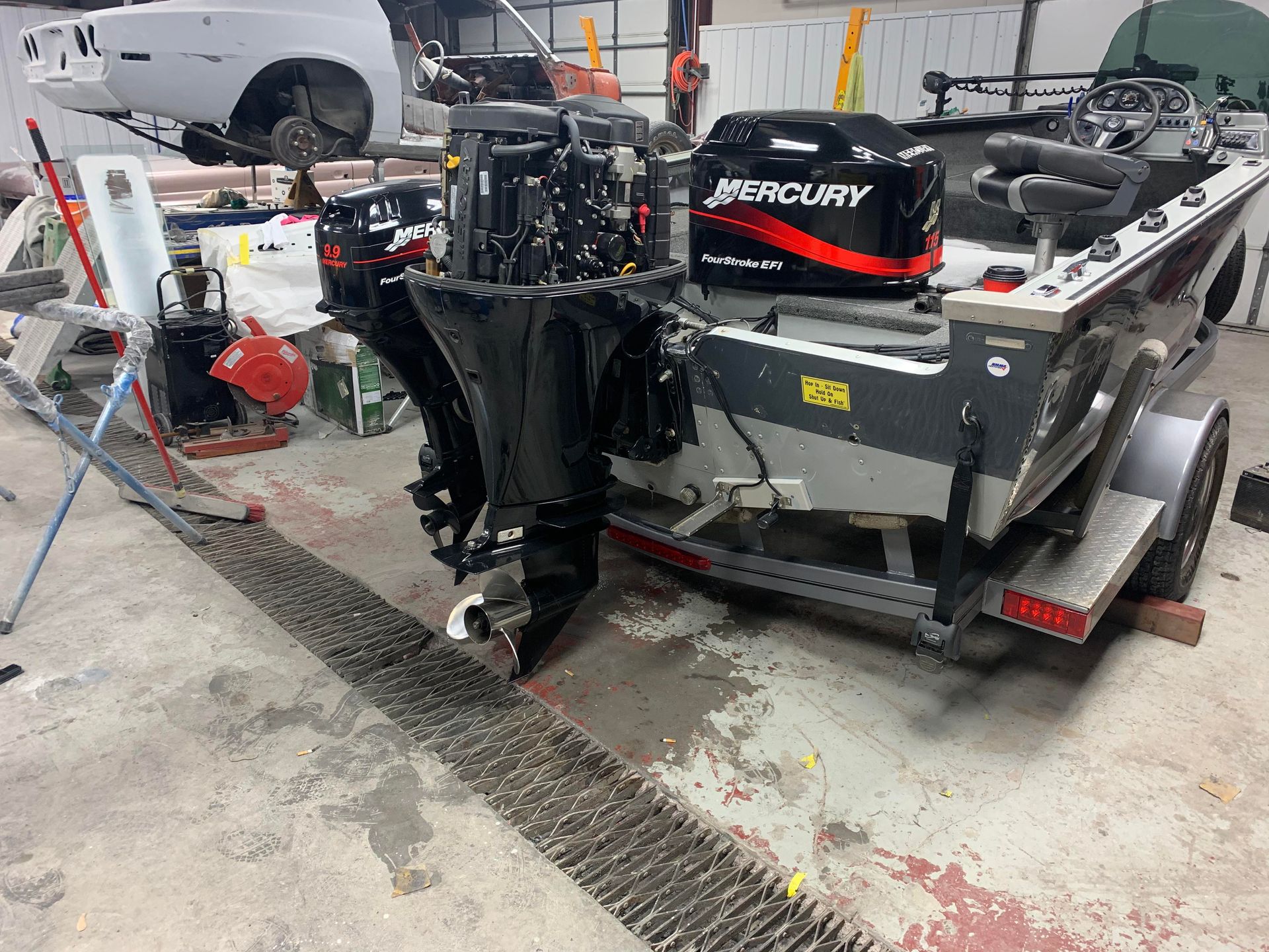 a mercury outboard motor is sitting on top of a boat in a garage
