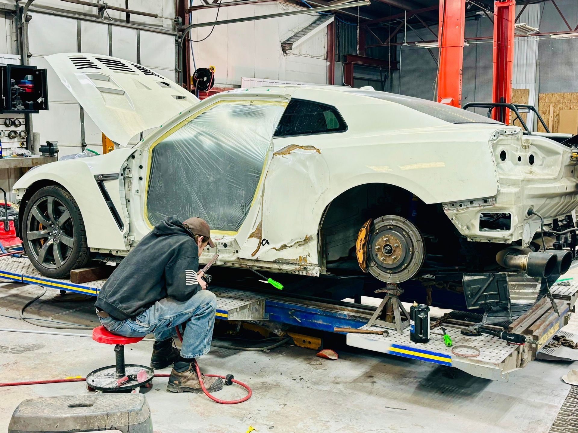a man is working on a white car in a garage