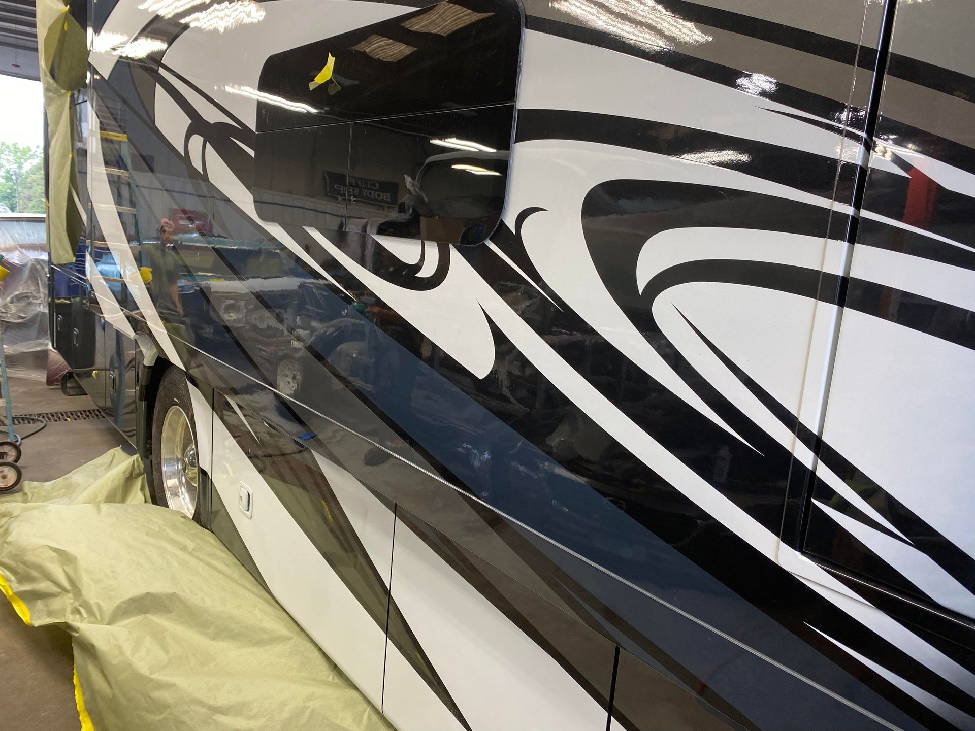 a black and white rv is being painted in a garage