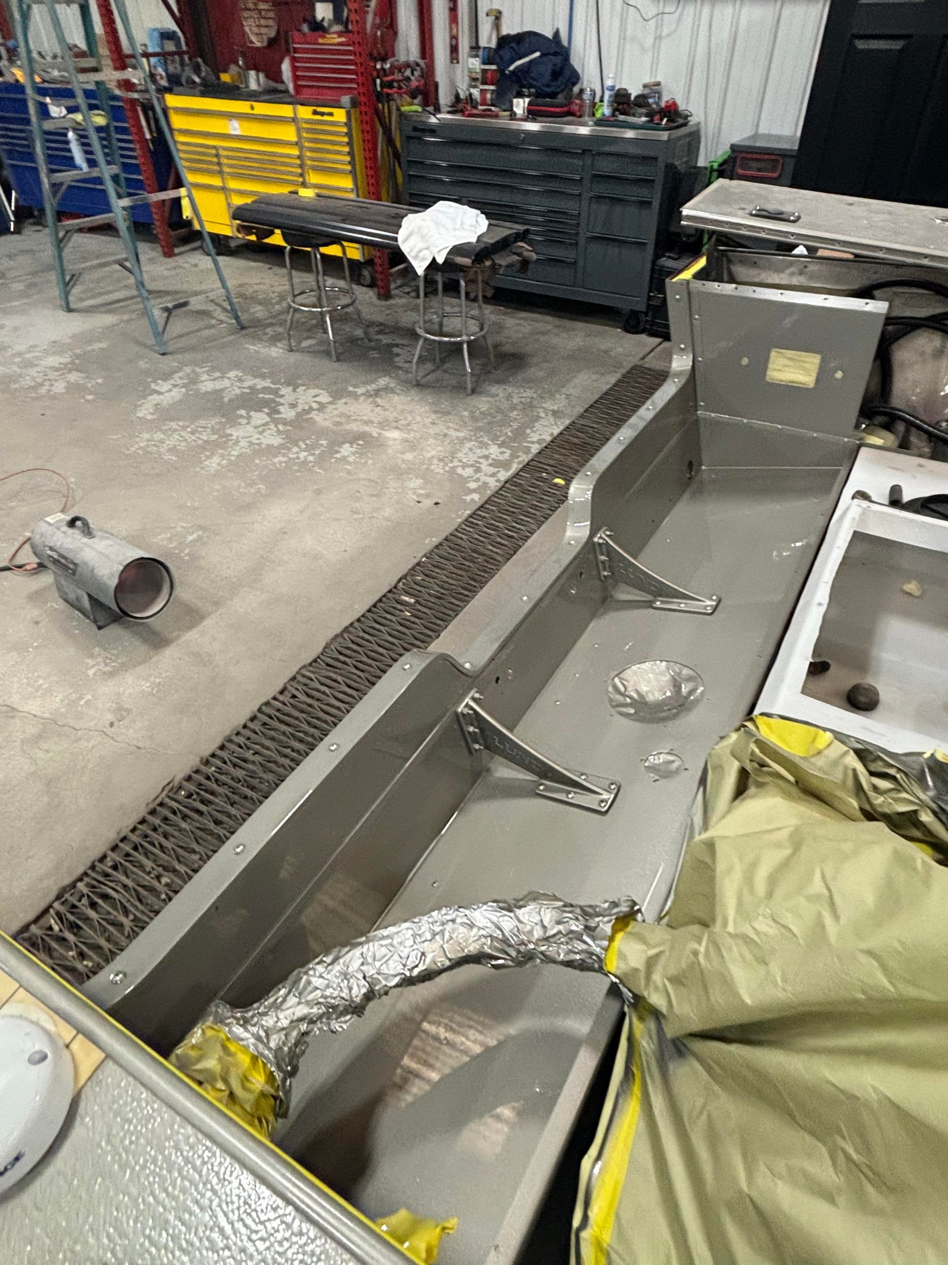 a stainless steel sink is being worked on in a garage
