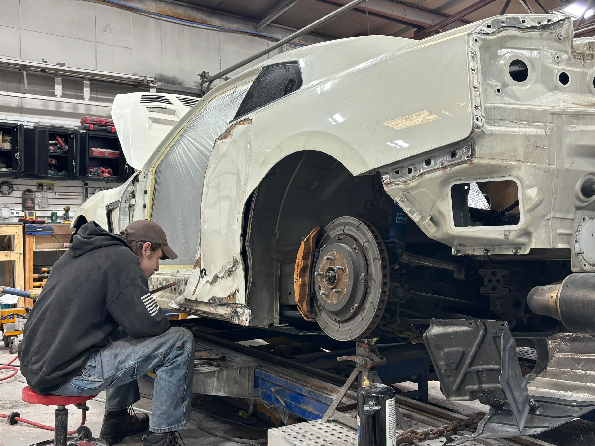 a man is working on a white car in a garage