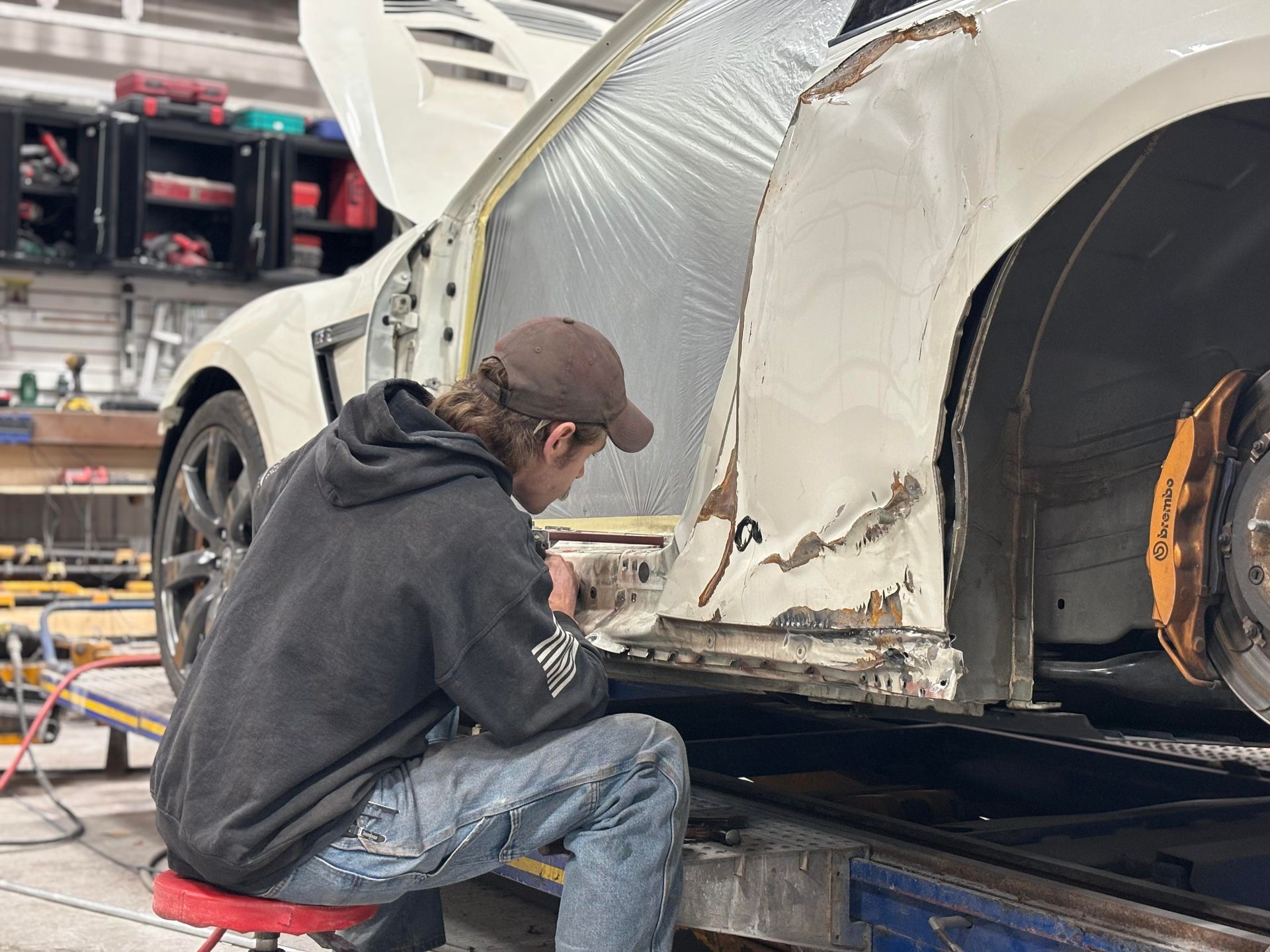 a man is working on a white car in a garage