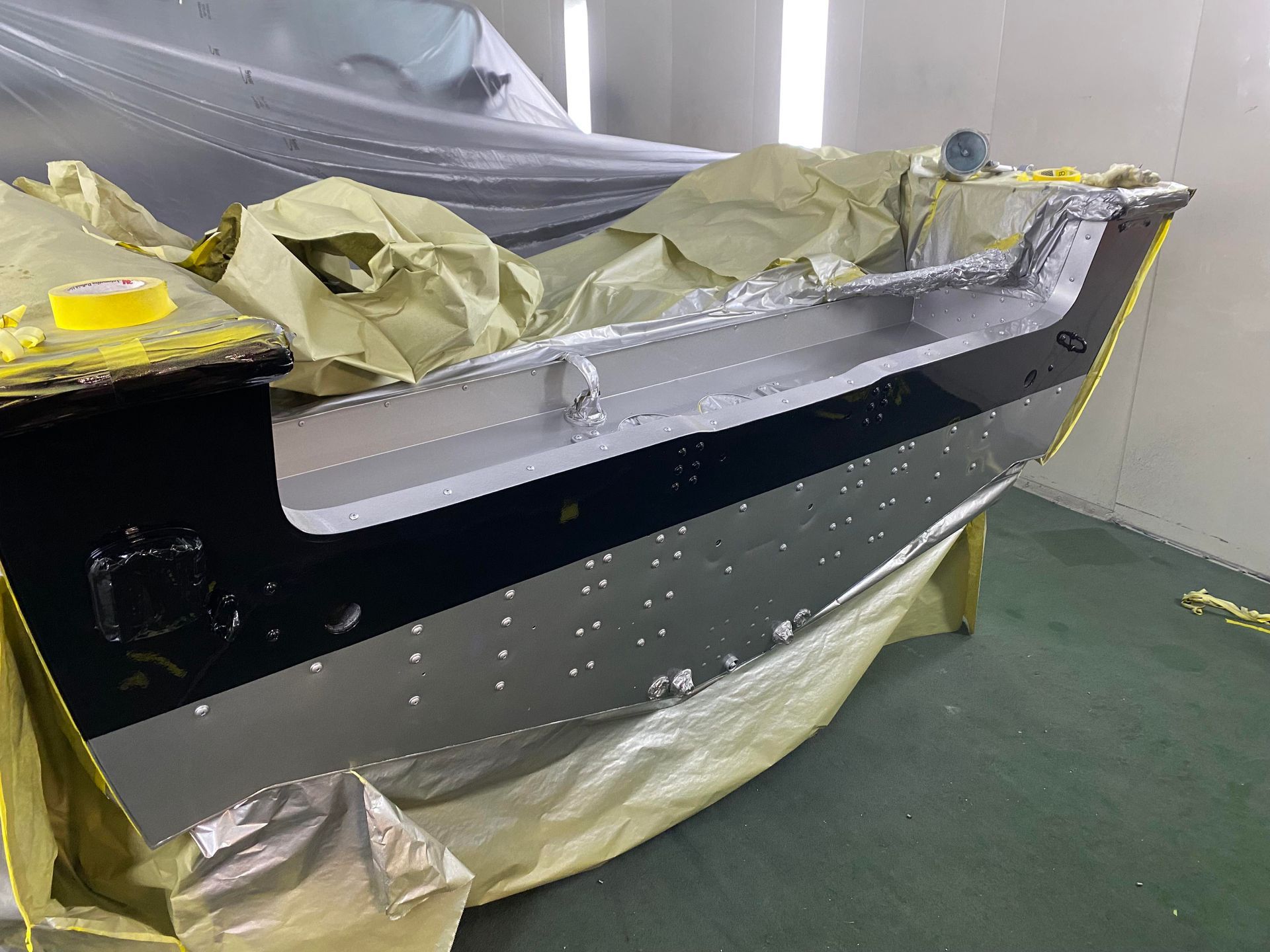 a boat is being painted in a paint booth