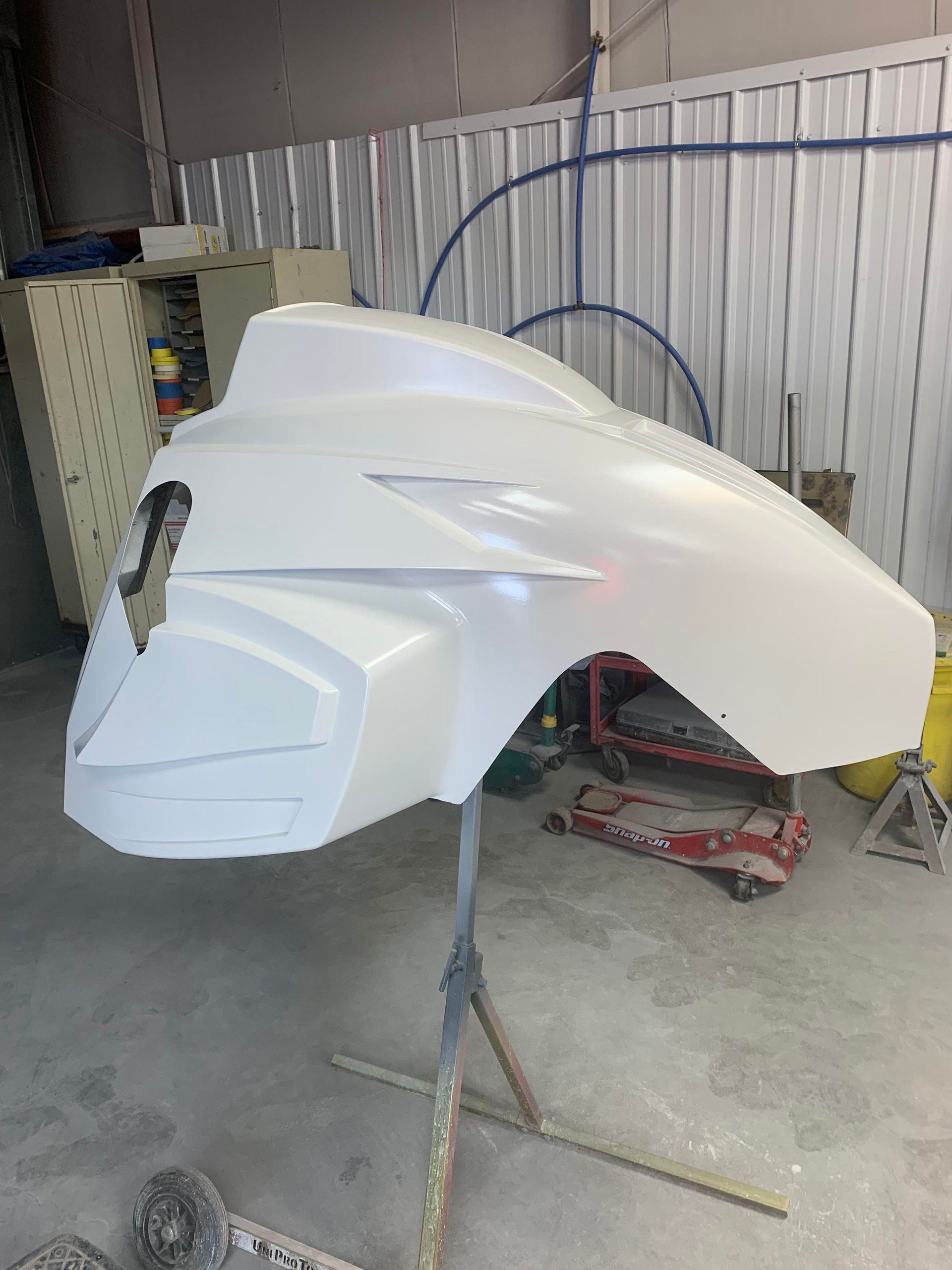 a white fender is sitting on a stand in a garage