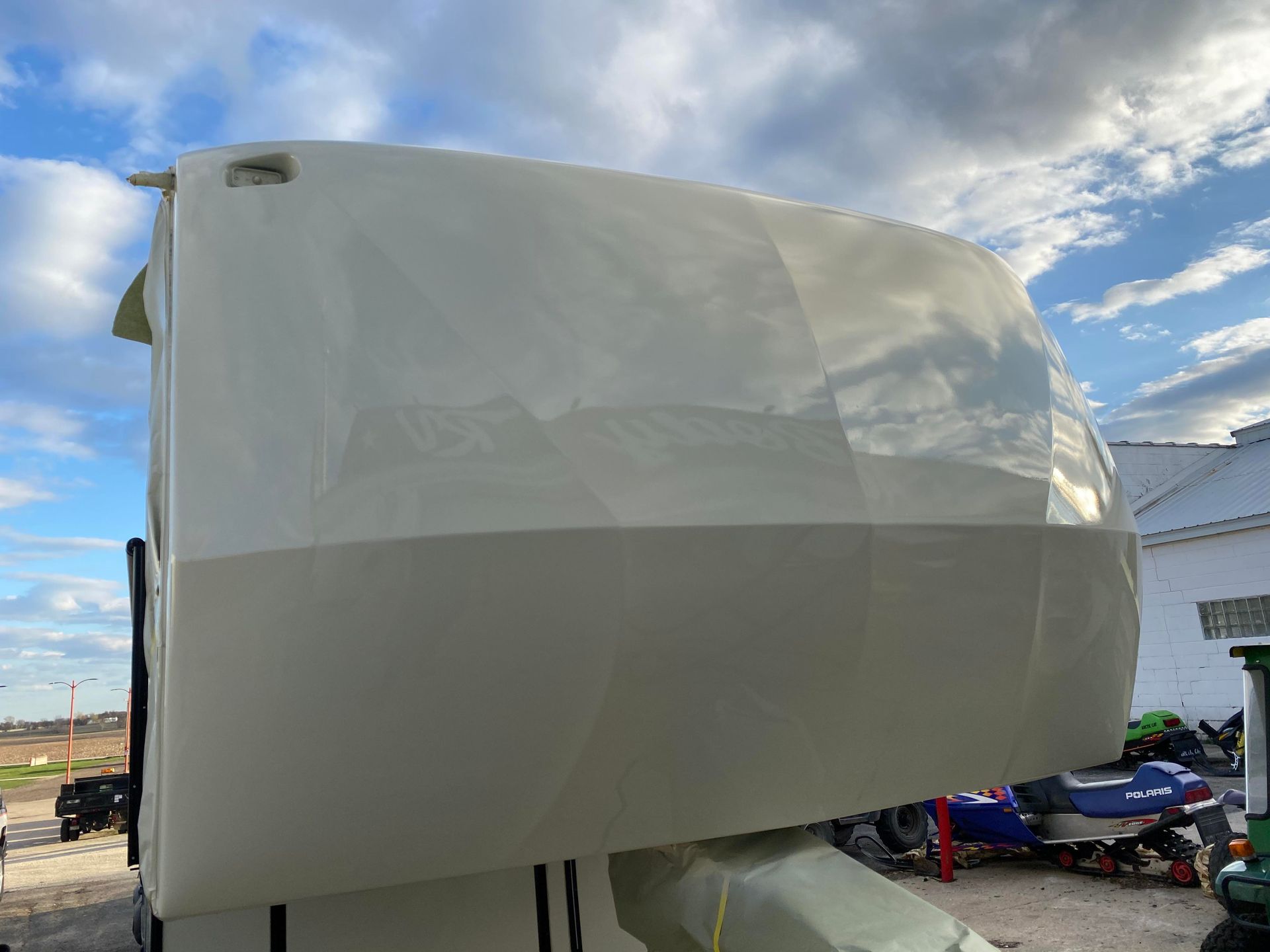 a white boat is parked in front of a building with a blue sky in the background