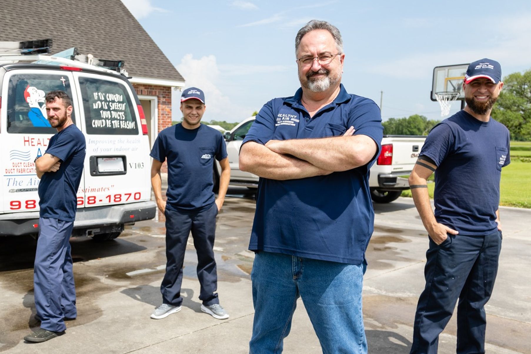 A group of men standing next to each other in front of a van.