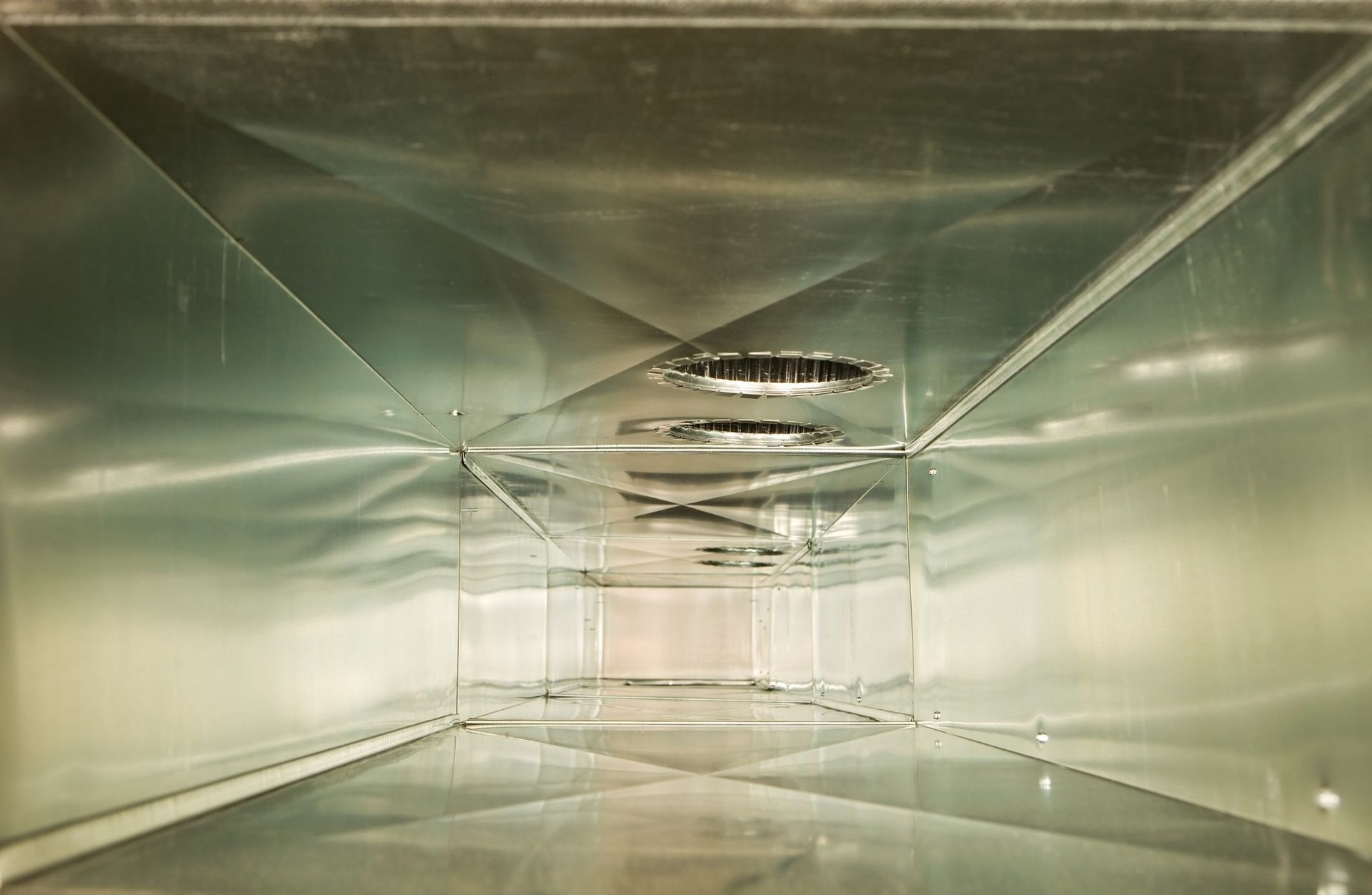 Looking down a metal duct in a building.