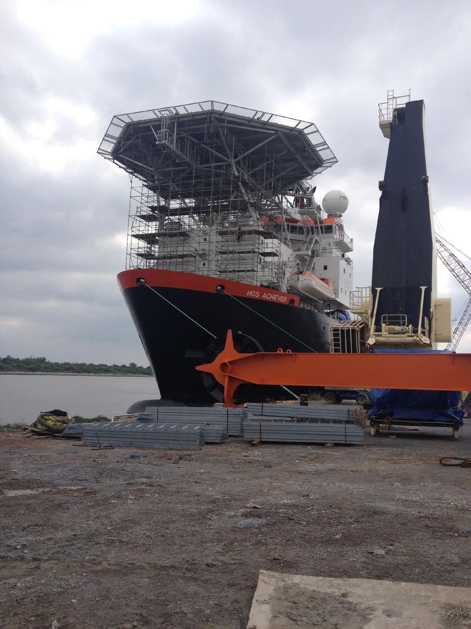 A large ship is sitting on the shore of a body of water