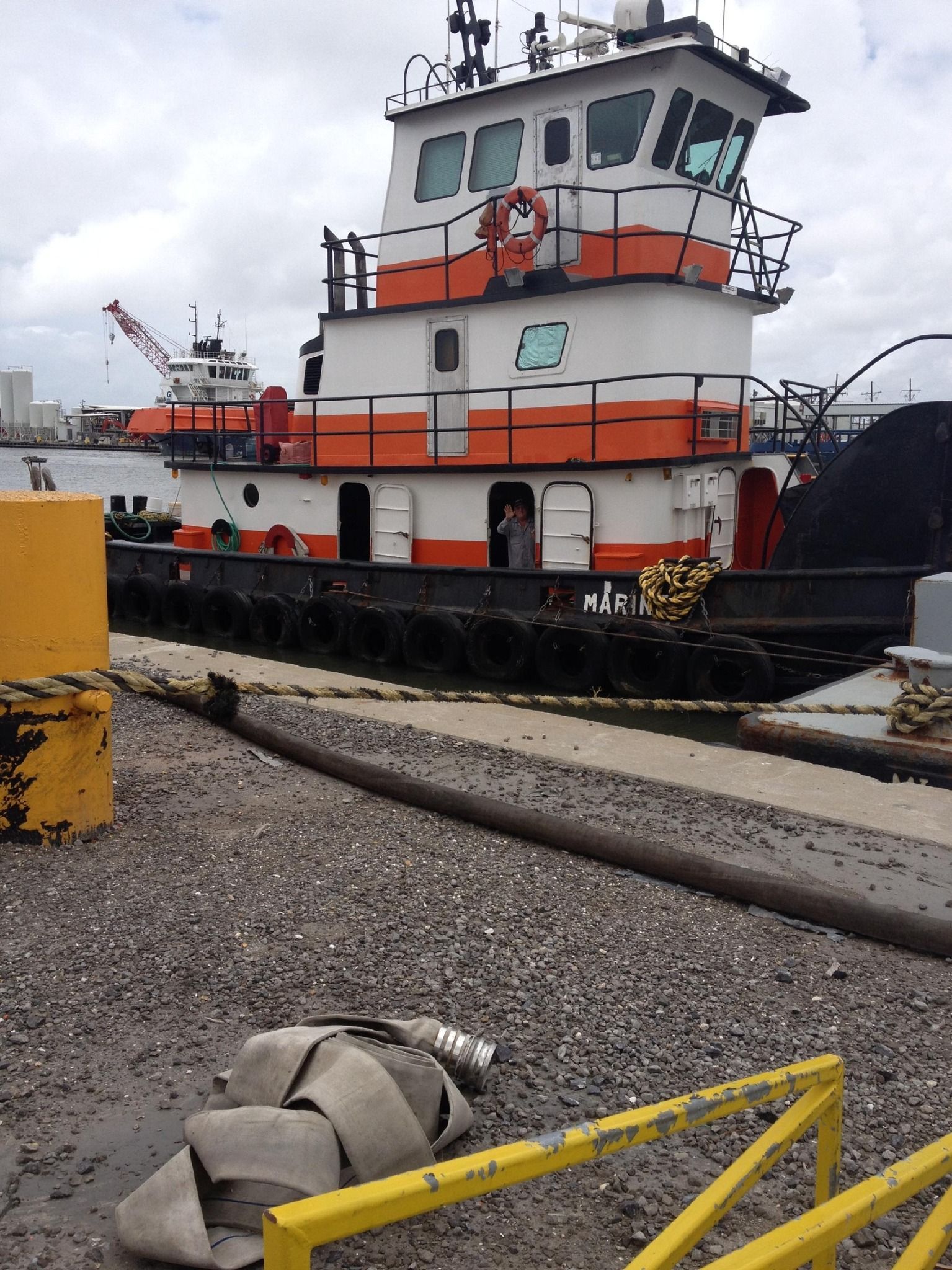 A large orange and white boat is docked in a harbor
