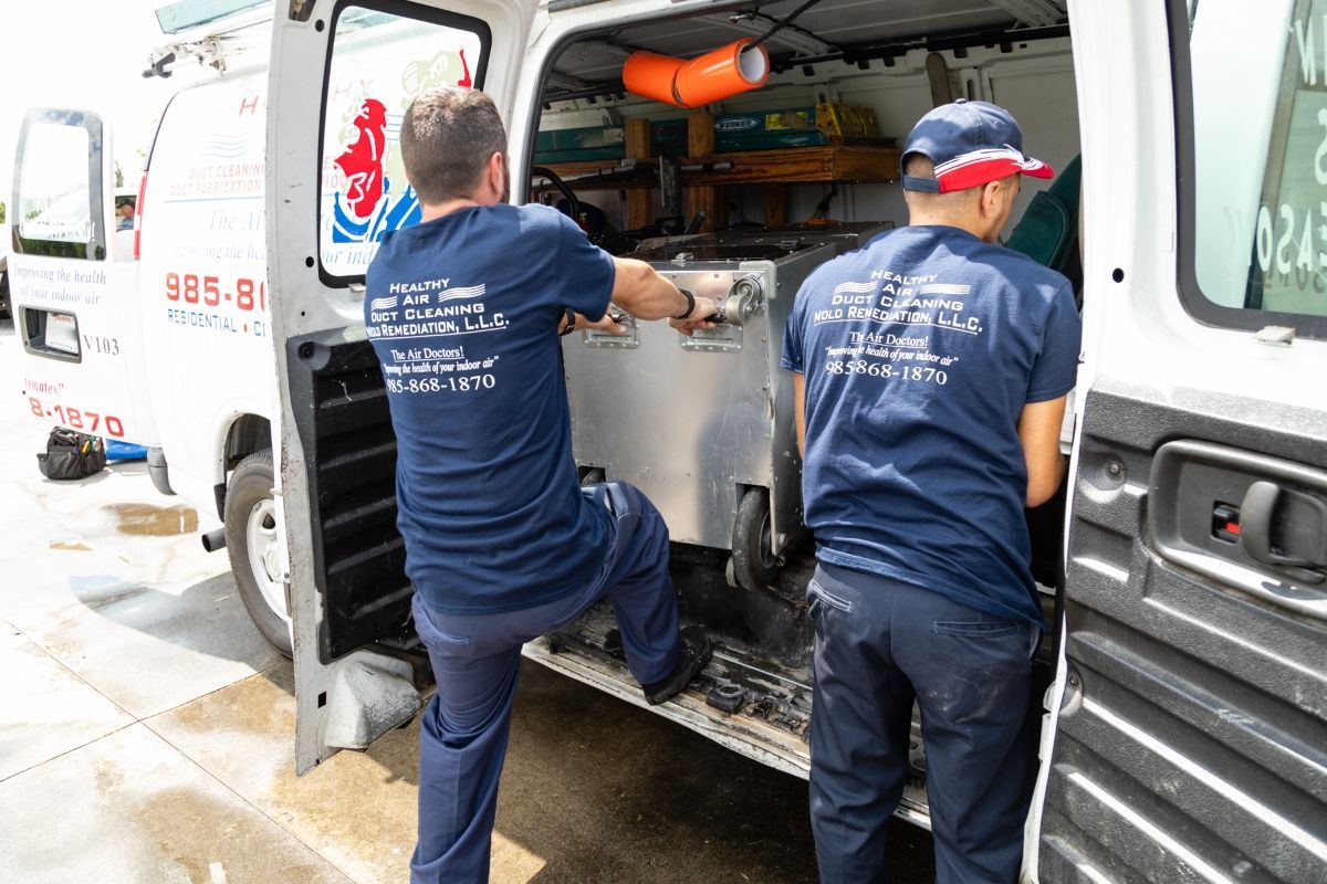 Two men are loading something into a van.