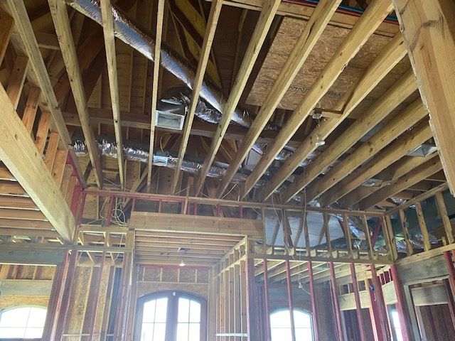 The ceiling of a building under construction with a lot of wooden beams.