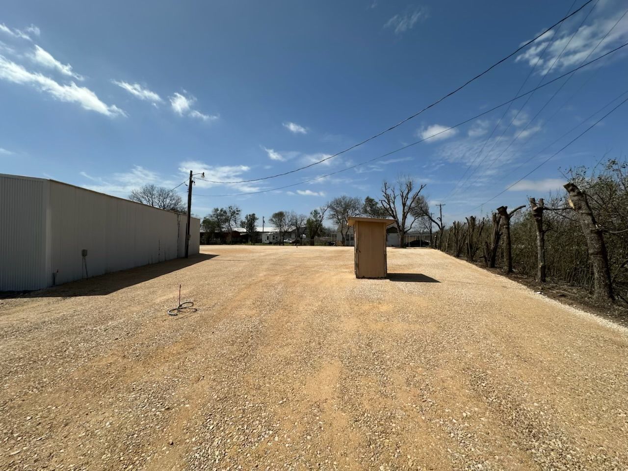 A dirt road with a fence in the background.