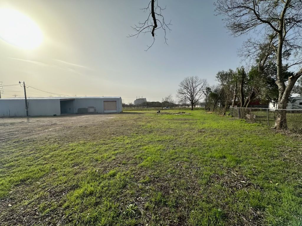 A large grassy field with a building in the background.