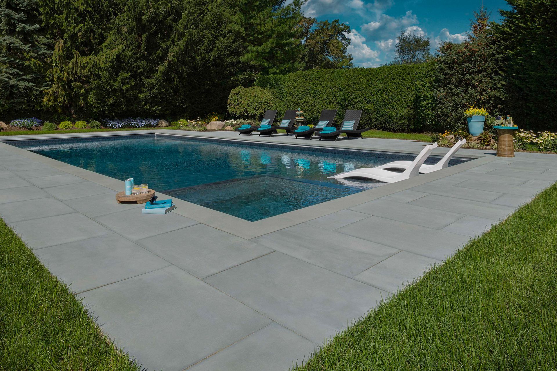 A large swimming pool surrounded by lawn chairs in a backyard.