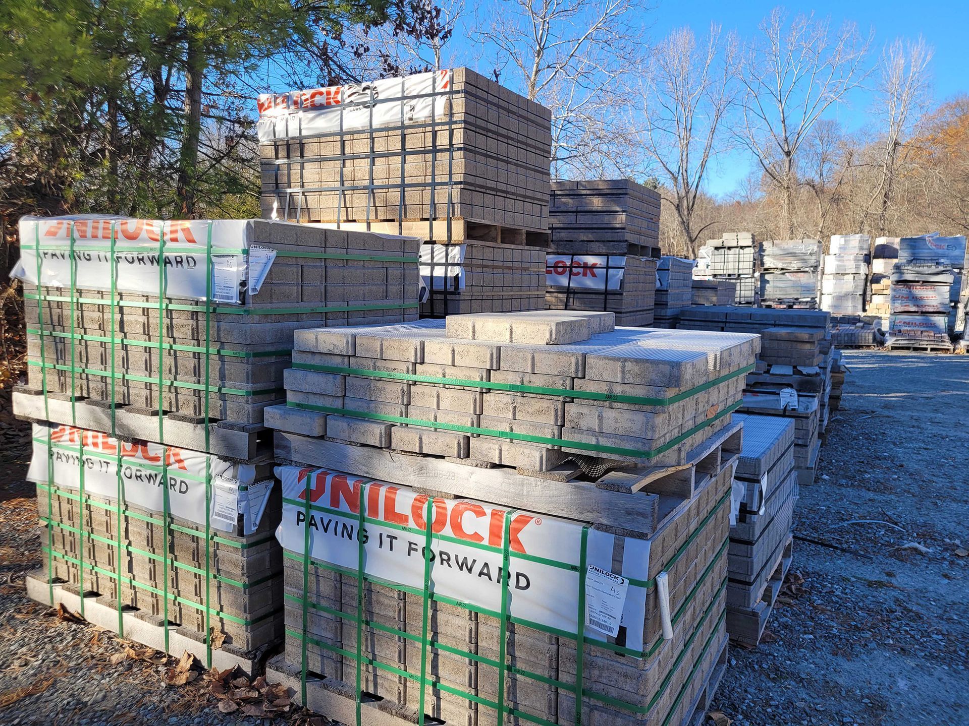 A bunch of bricks are stacked on top of each other in a yard.