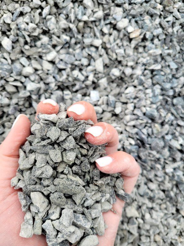 A person is holding a pile of gravel in their hand.