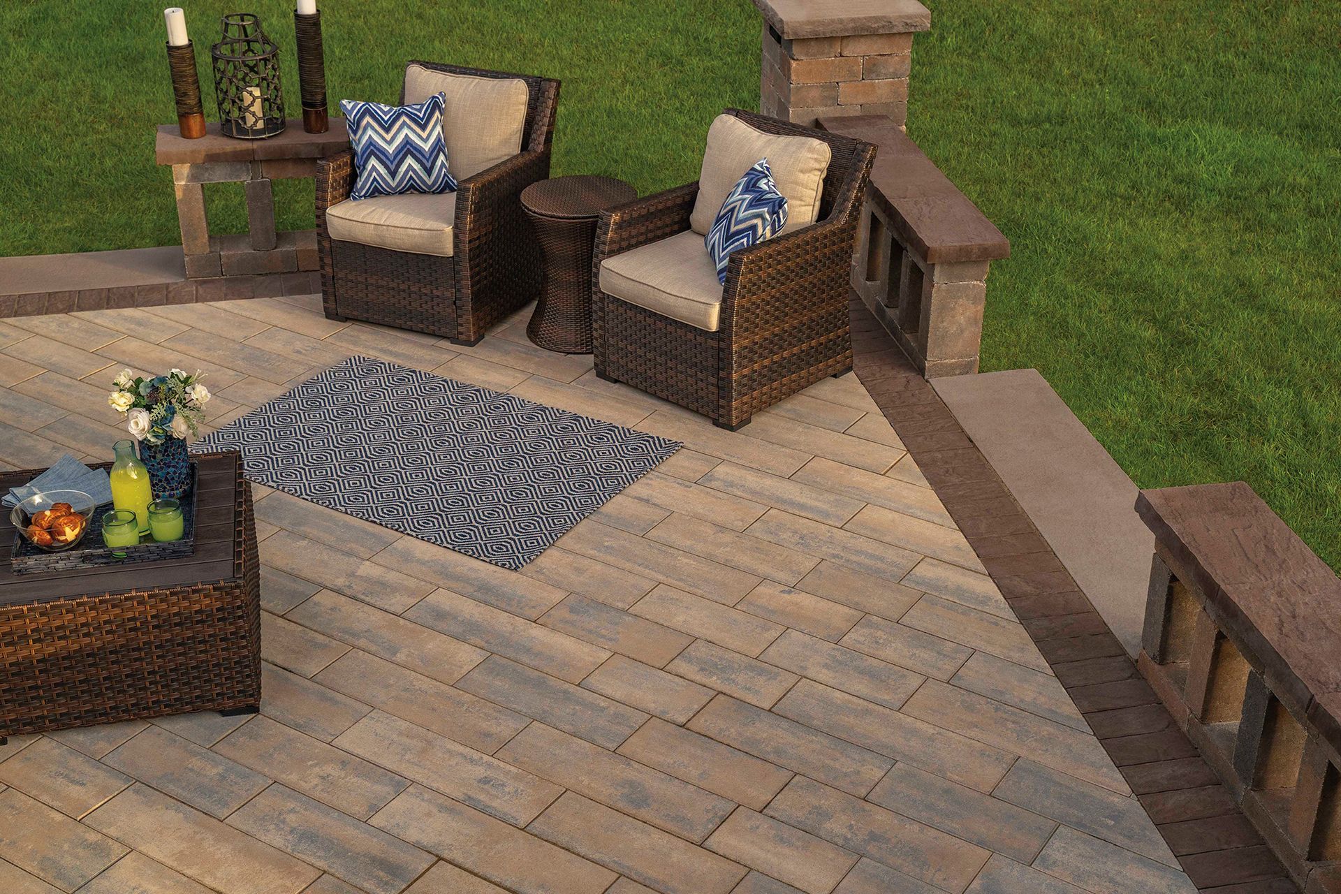 A patio with chairs , a coffee table , and a rug.
