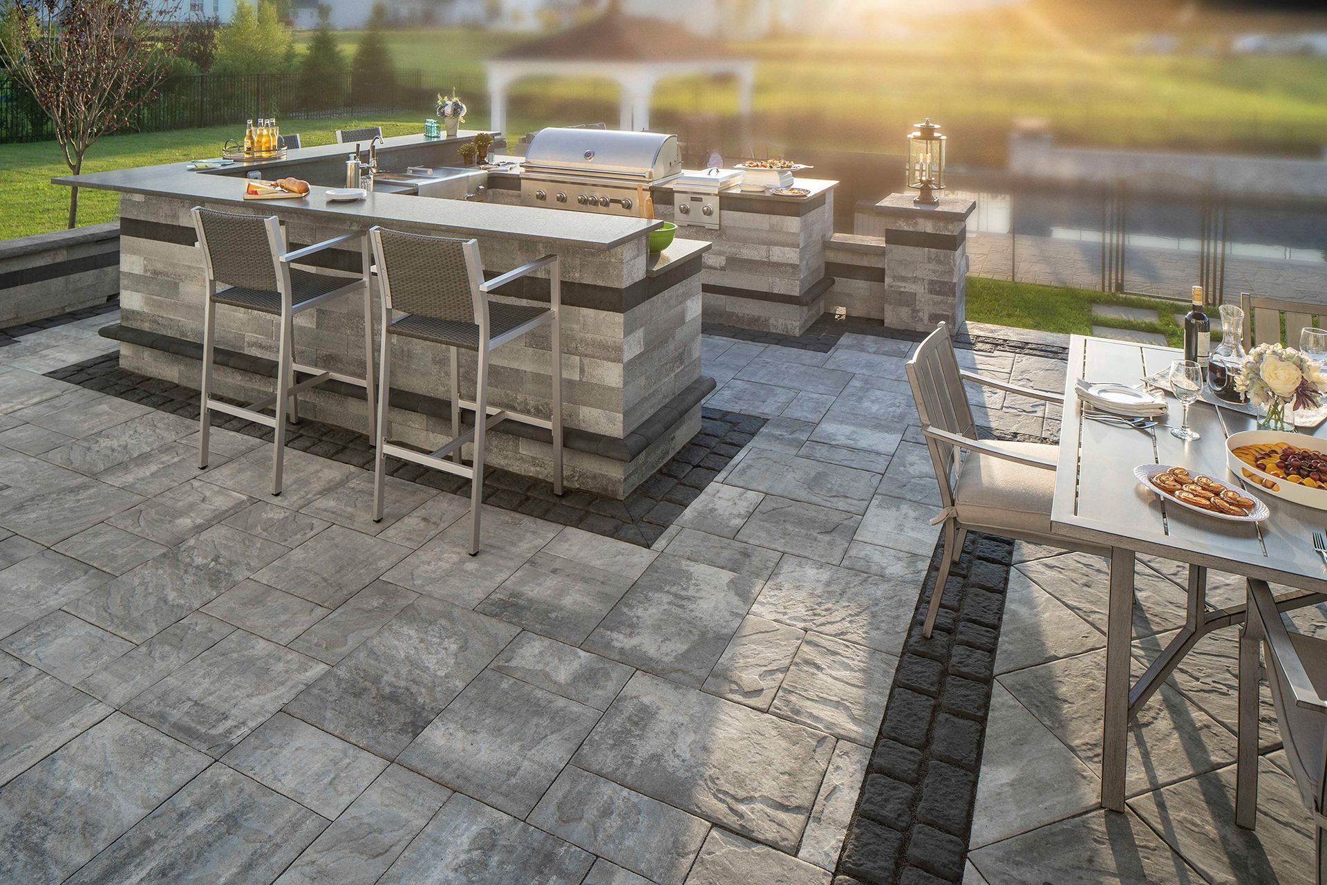 A patio with a table and chairs and a grill.