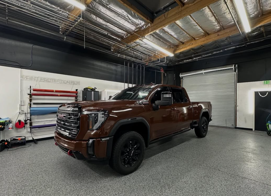 A brown truck with a garage door is parked in a garage.