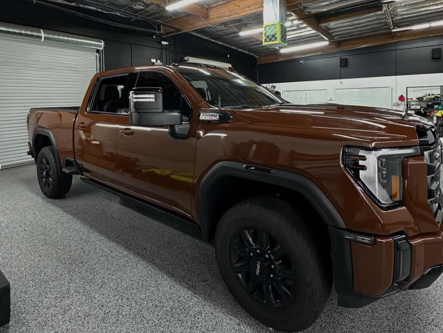 A brown pickup truck is parked in a garage.