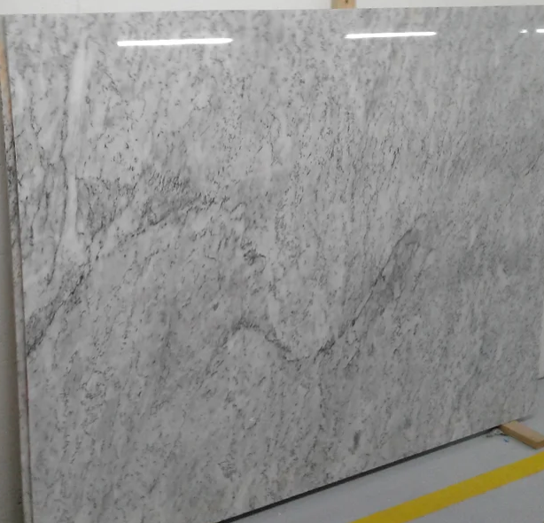 A large white marble slab is sitting on the floor next to a yellow line.