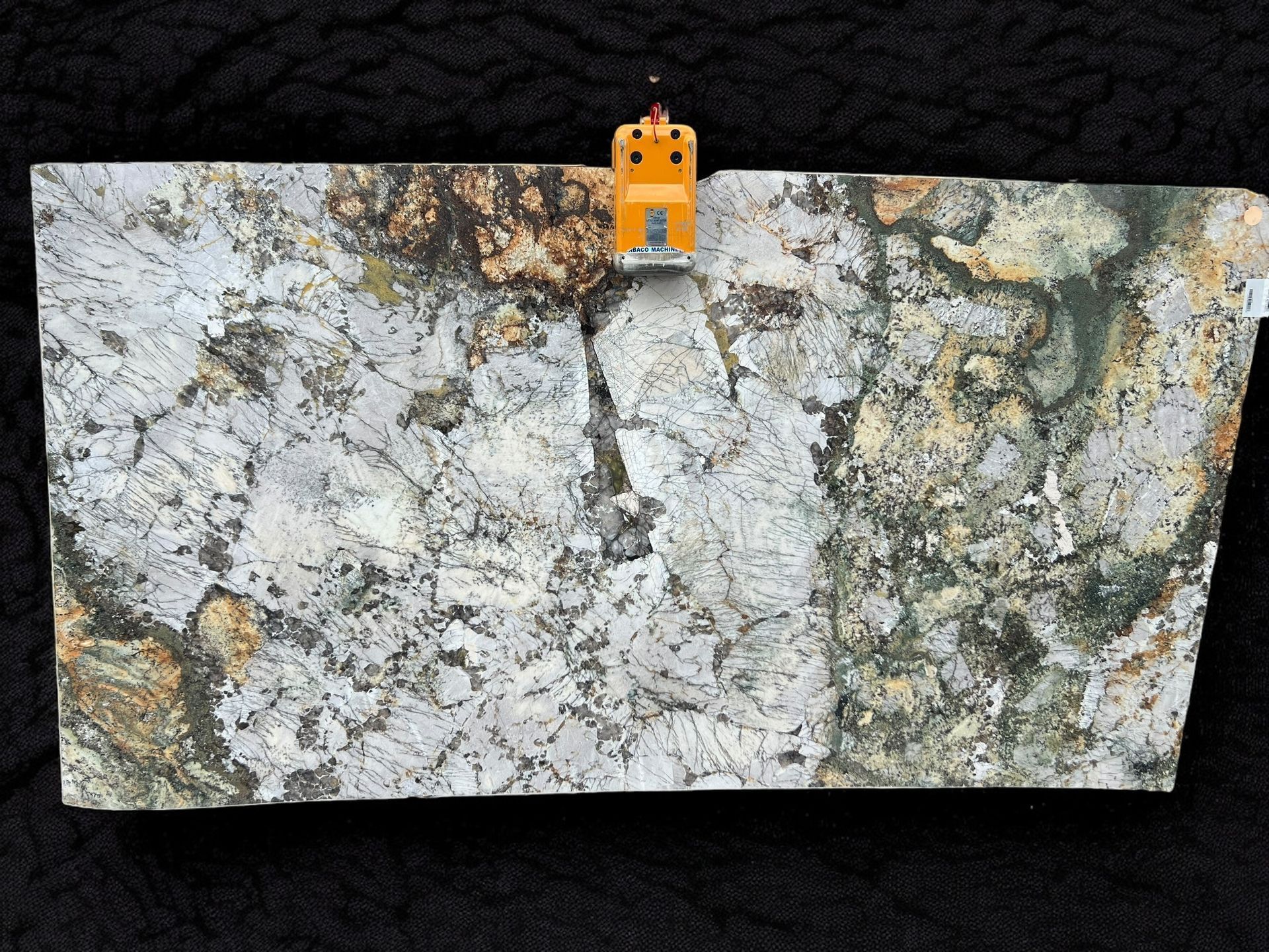 A piece of granite is sitting on a black surface.