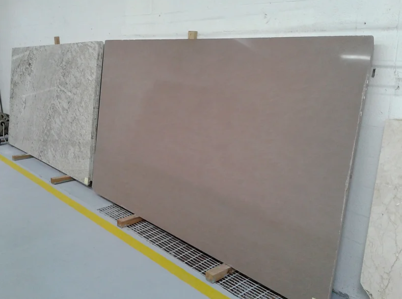 A row of marble slabs are lined up in a warehouse