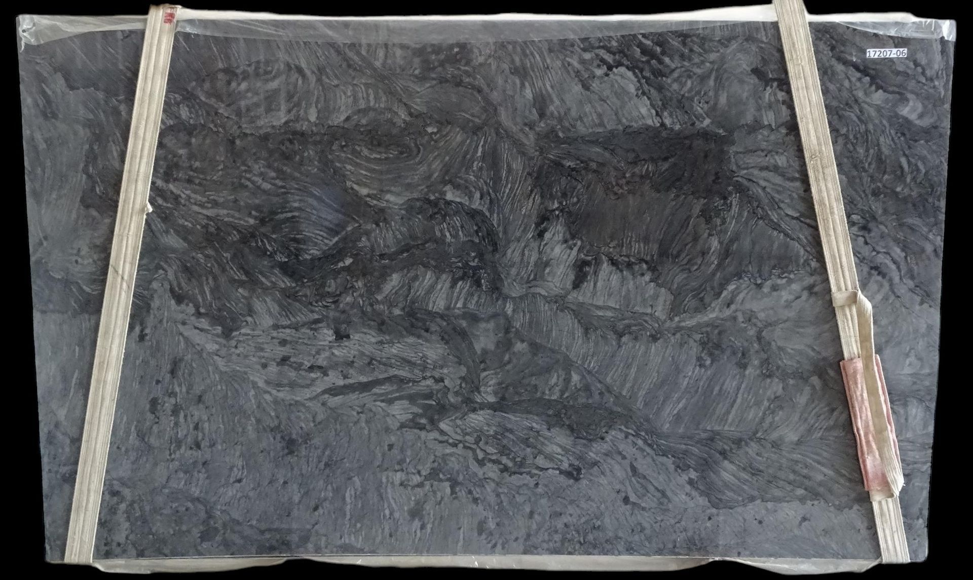 A large piece of marble is being displayed on a black background.
