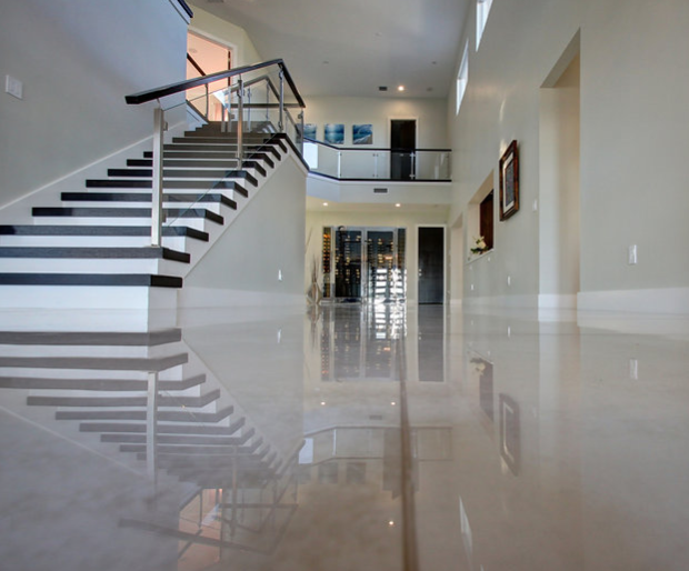 A hallway with stairs and a reflection of the stairs in the floor