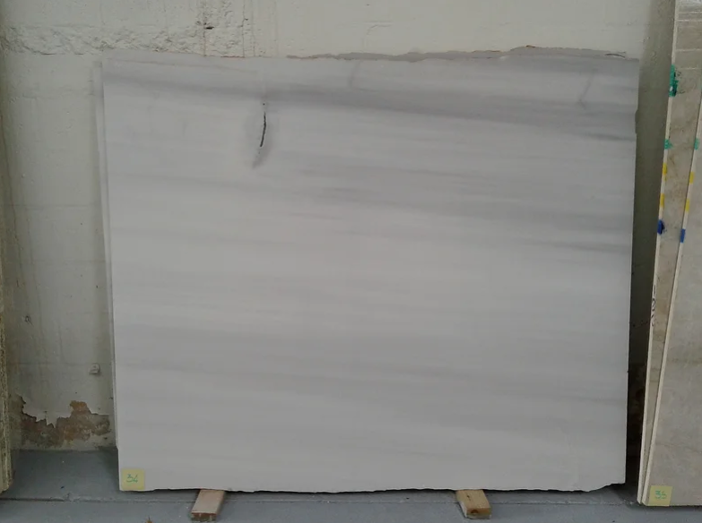 A white marble slab is sitting on top of a wooden pallet.