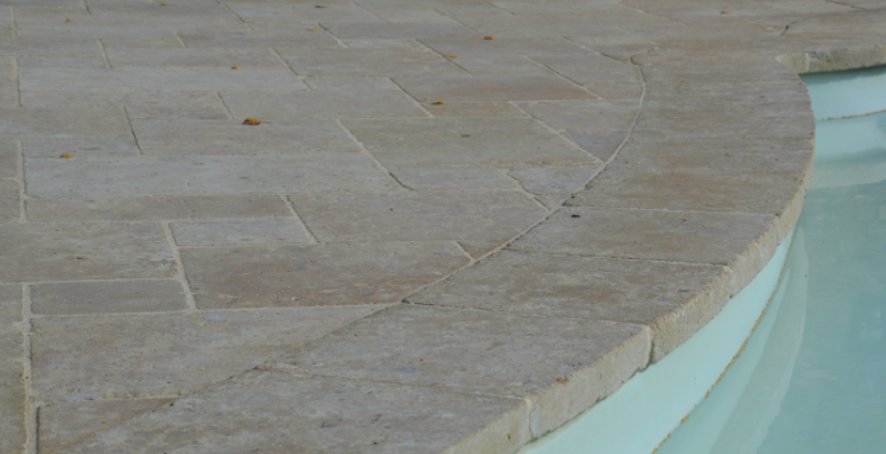 A close up of a tiled edge of a swimming pool.