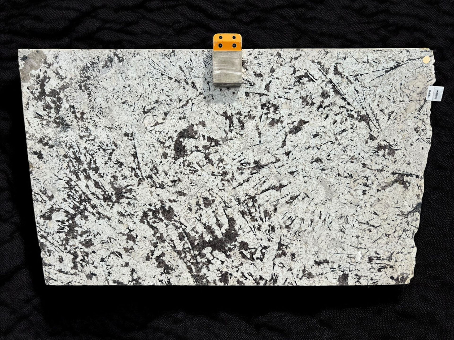 A piece of granite is sitting on a black surface.