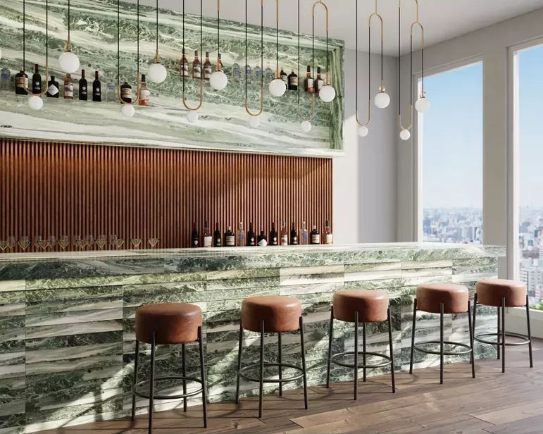 A bar with stools and bottles hanging from the ceiling