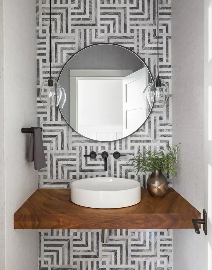 A bathroom with a sink, mirror, and wooden counter top