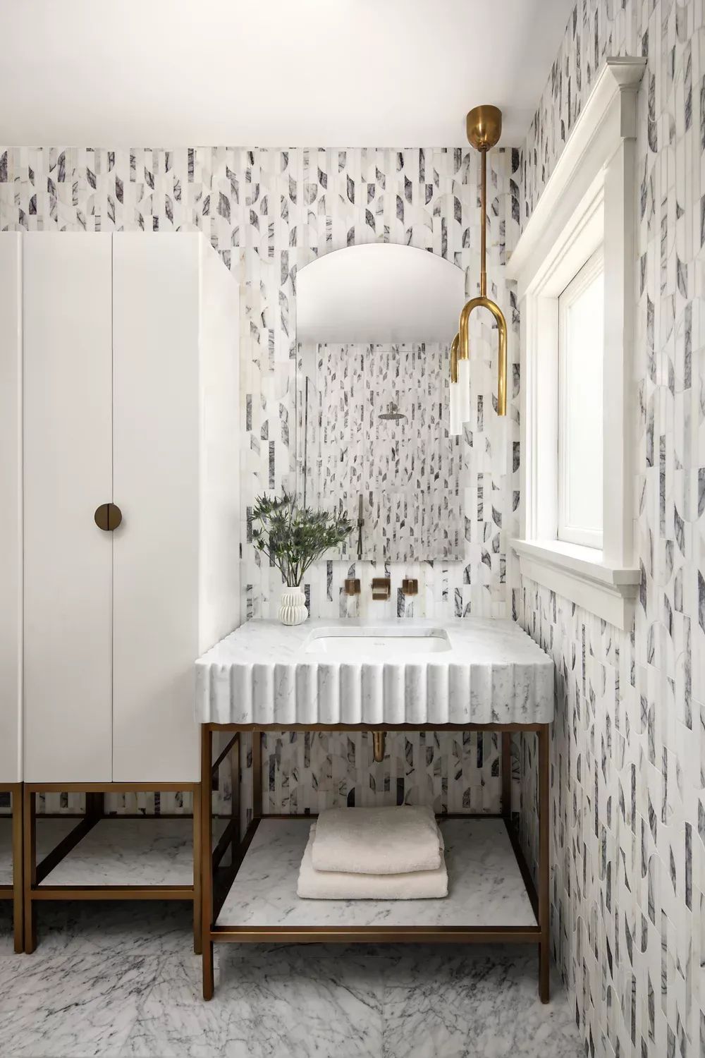A bathroom with a sink, mirror, and cabinet