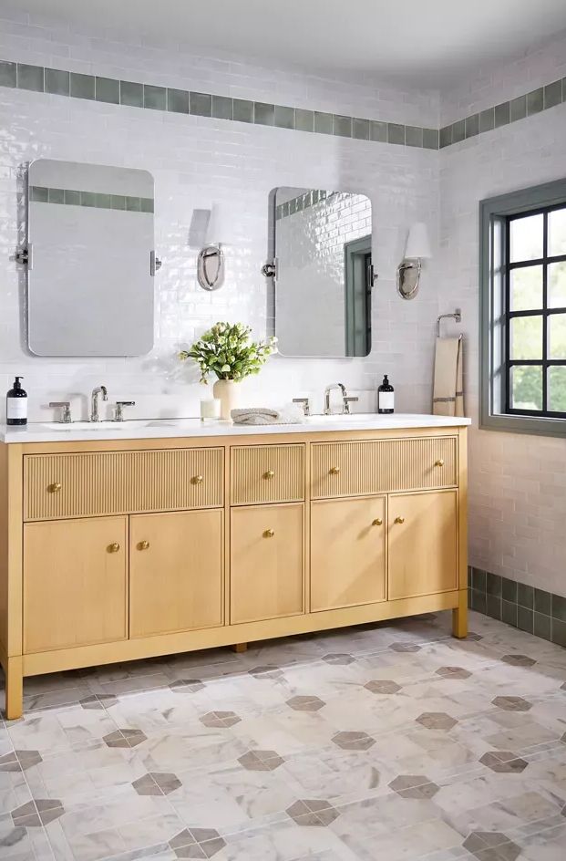 A bathroom with two sinks, a mirror, and a window