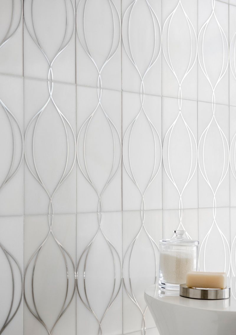 A bathroom with white tiles and a candle on the sink