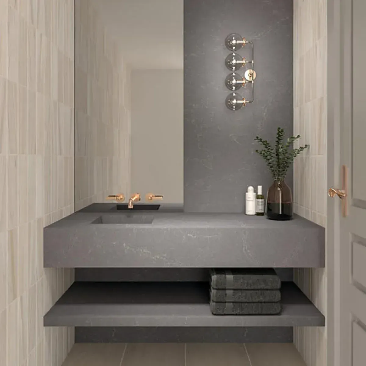 Modern bathroom with gray countertop sink and shelf. Bronze faucet and sconce, towels, and vase.