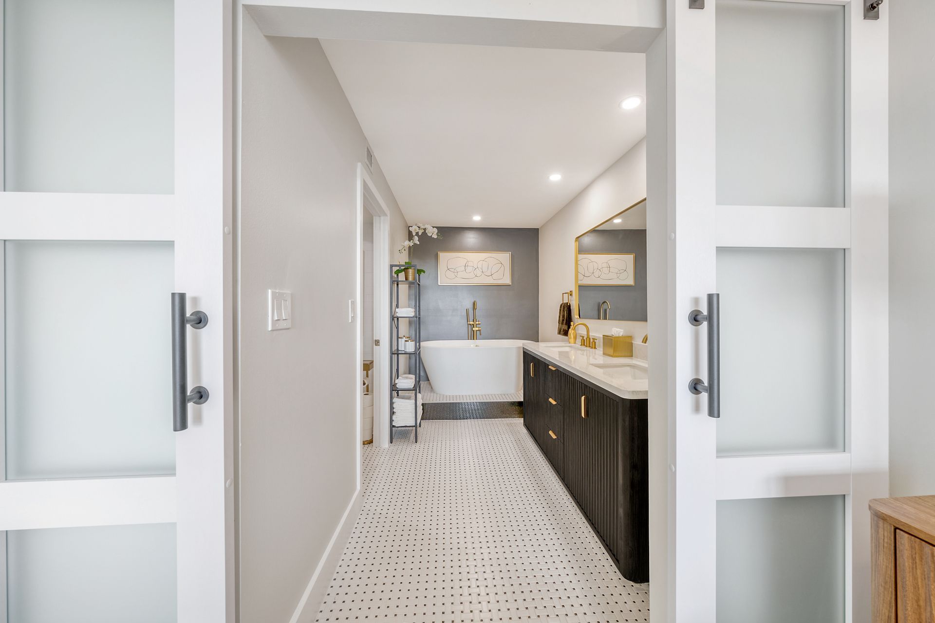 A bathroom with a bathtub , sink , mirror and sliding glass doors.
