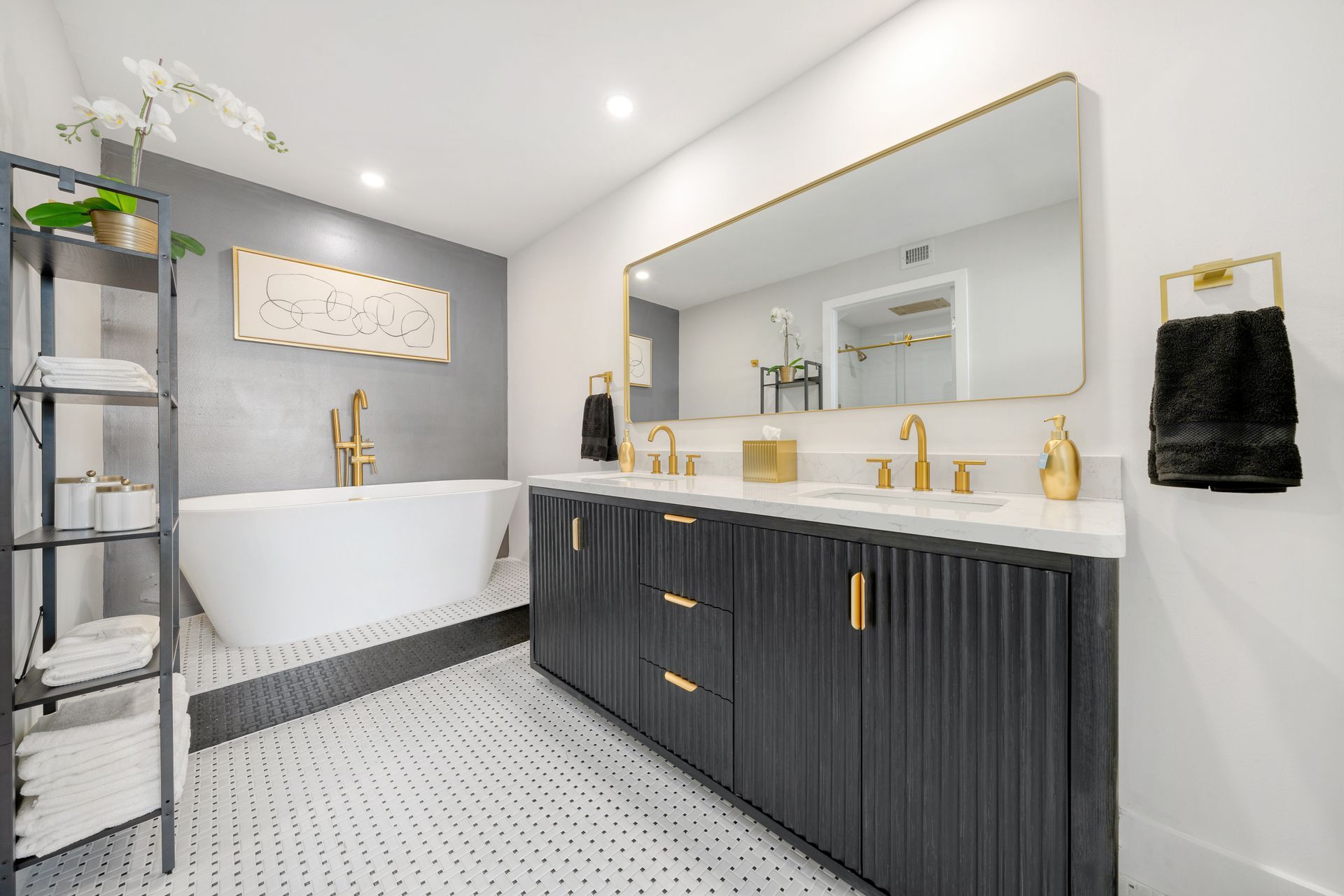 A bathroom with two sinks , a bathtub , and a large mirror.