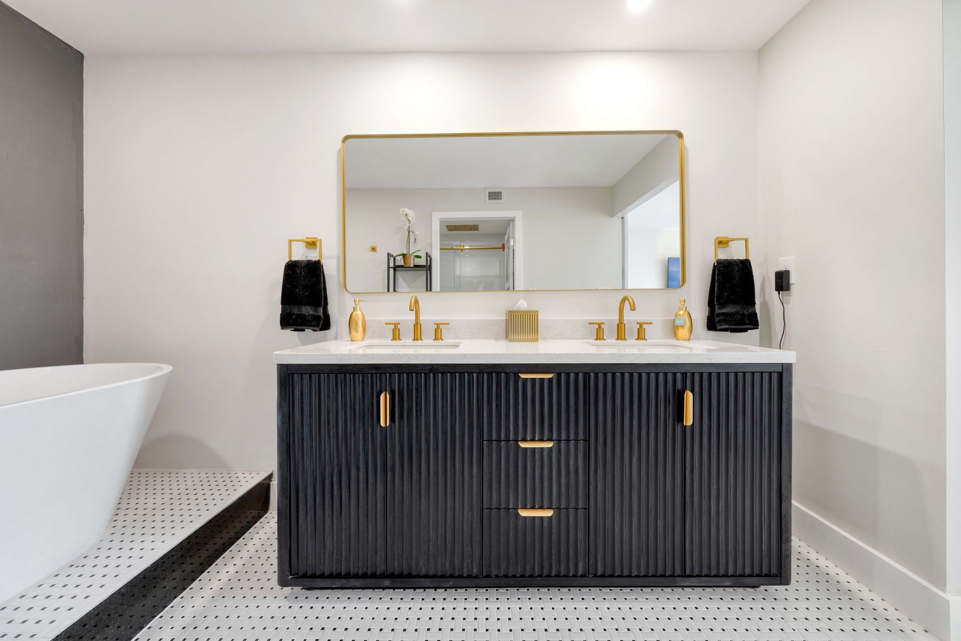 A bathroom with two sinks , a large mirror and a bathtub.