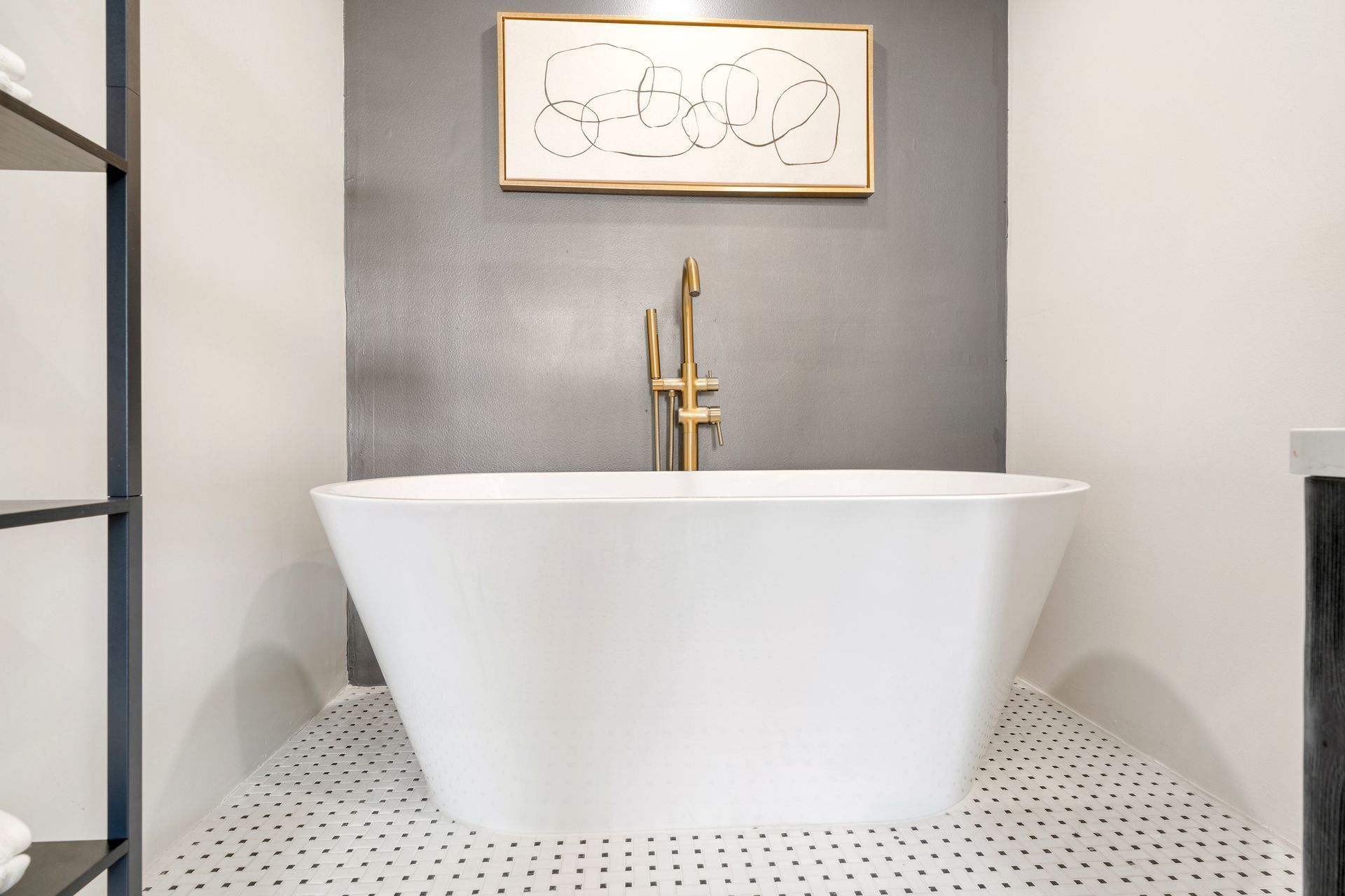 A bathroom with a bathtub and a picture on the wall above it.