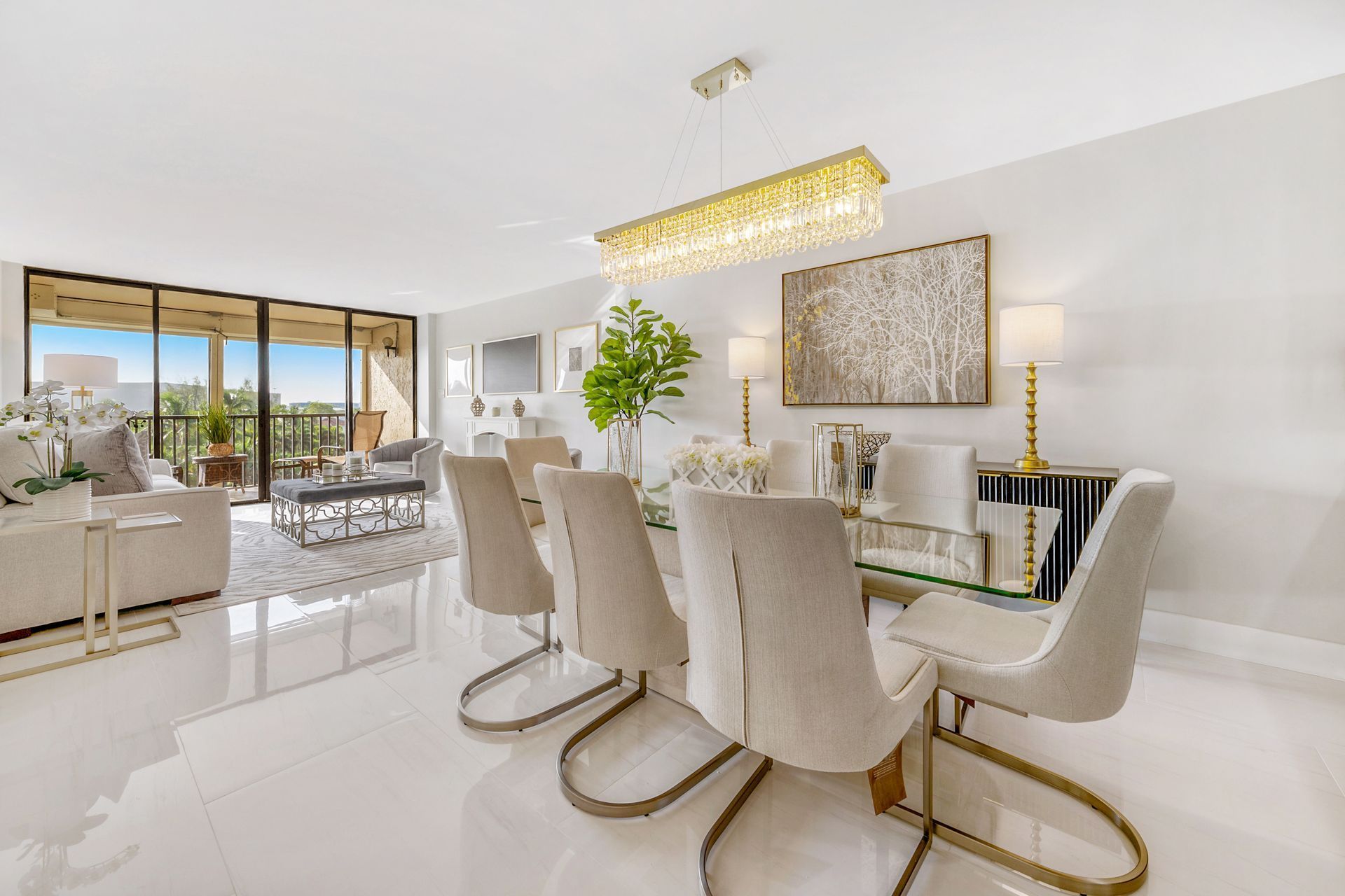 A living room with a dining table and chairs and a chandelier.