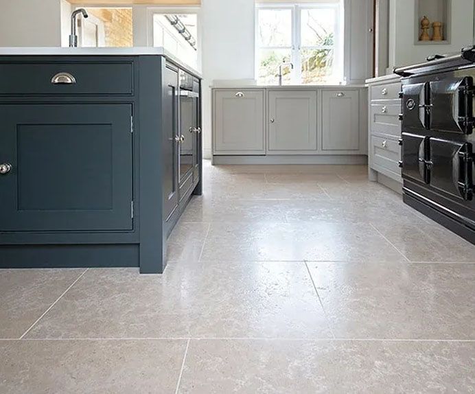 A kitchen with a tiled floor and a black stove.