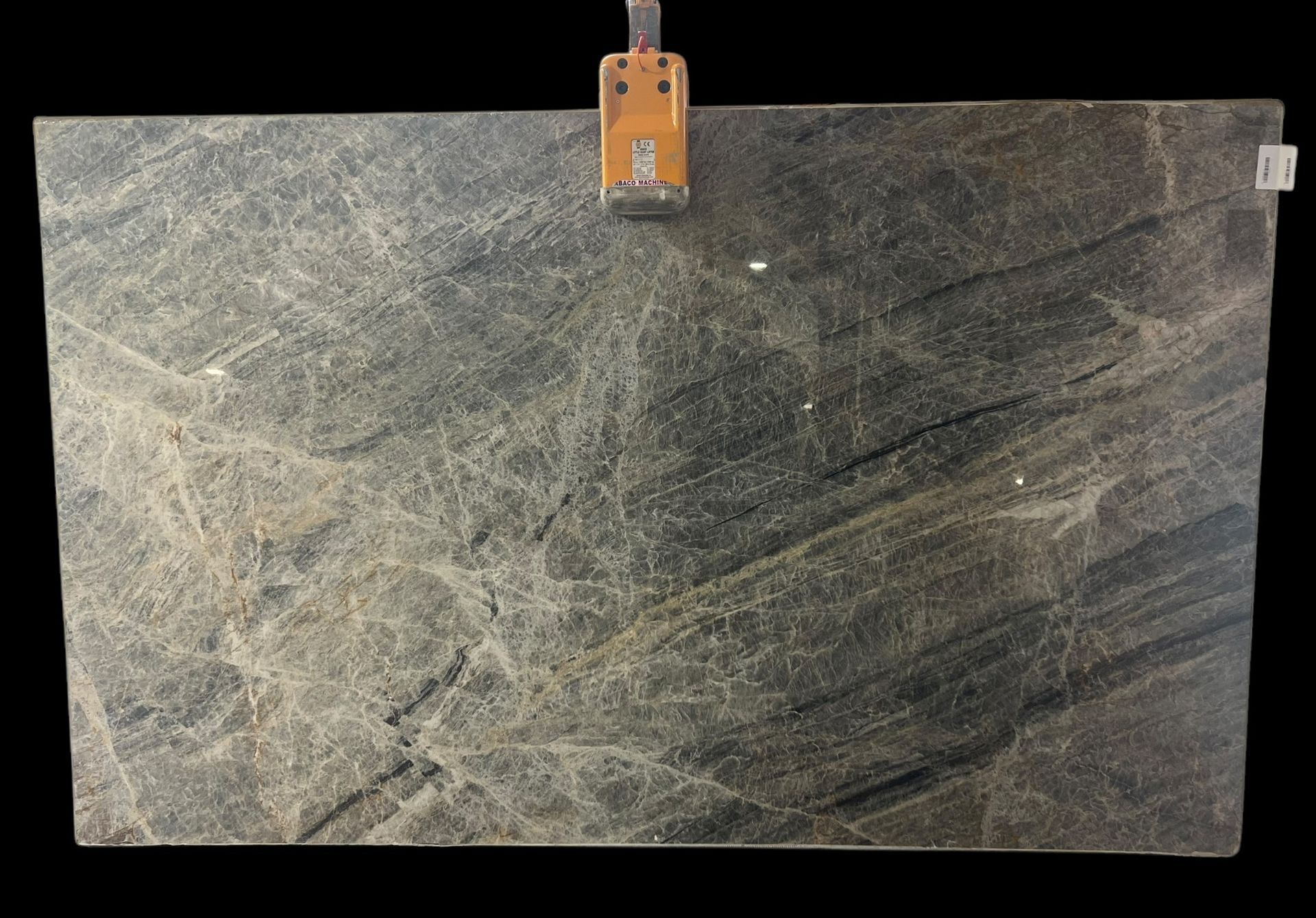 A large piece of marble is hanging on a hook on a black background.